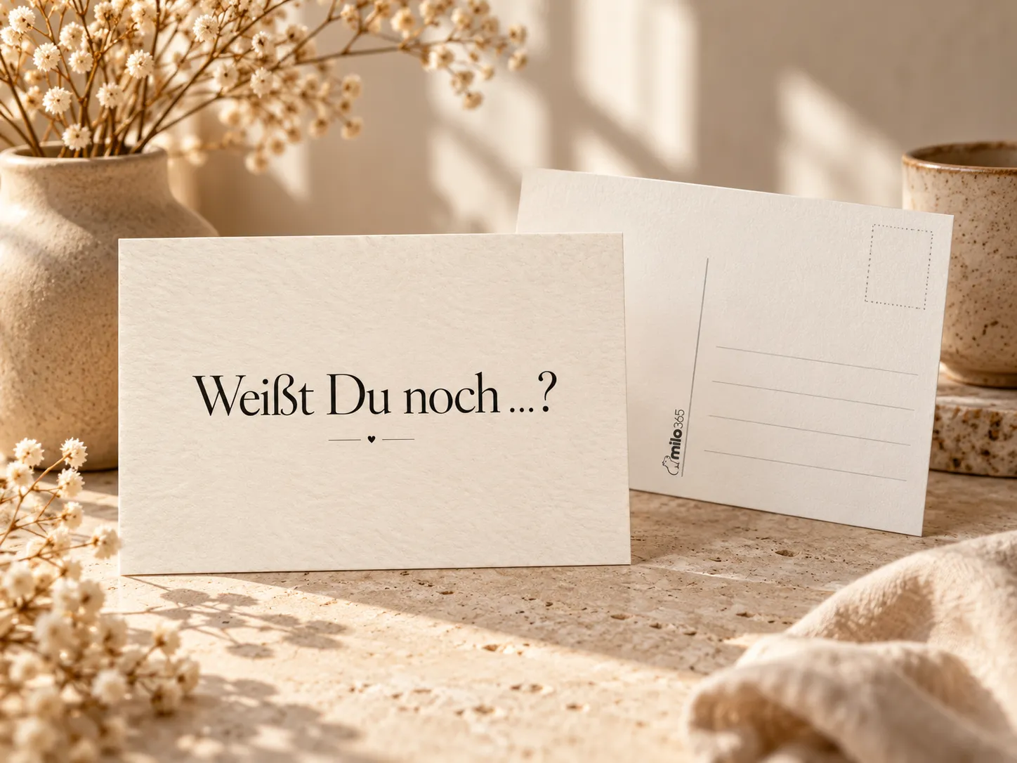 Postkarte „Weißt Du noch …?“: vorn aufgestellt die Vorderseite, dahinter die Rückseite mit Briefmarkenfeld und Adresslinien